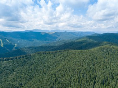 Yazın Ukrayna Karpatları 'nın yeşil dağları. Güneşli bir gün, nadir bulutlar. Hava aracı görünümü.