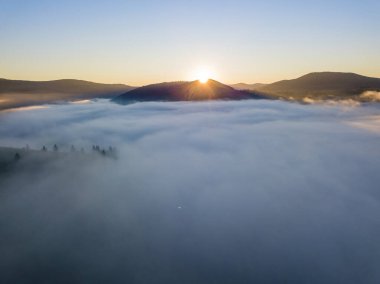Ukrayna Karpatları 'nda sisin üstünde gün doğumu. Hava aracı görünümü.