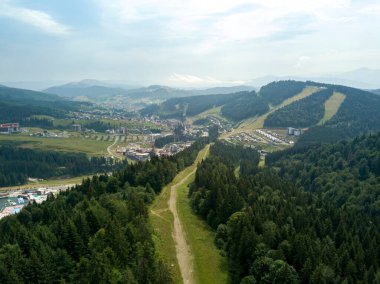 Yazın Ukrayna Karpatları 'nın yeşil dağları. Güneşli bir gün, nadir bulutlar. Hava aracı görünümü.