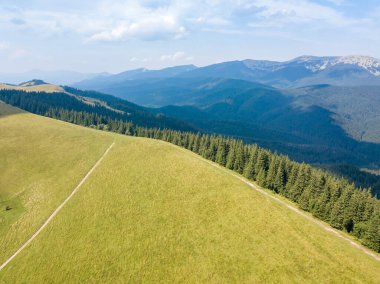 Yazın Ukrayna Karpatları 'nın yeşil dağları. Güneşli bir gün, nadir bulutlar. Hava aracı görünümü.
