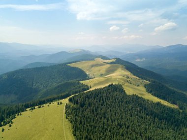 Yazın Ukrayna Karpatları 'nın yeşil dağları. Güneşli bir gün, nadir bulutlar. Hava aracı görünümü.