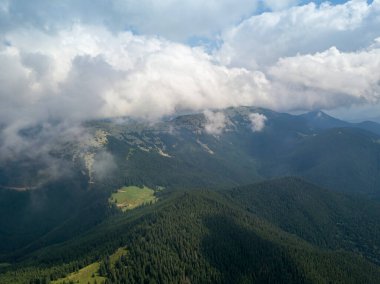 Yazın Ukrayna Karpatları 'nın yeşil dağları. Güneşli bir gün, nadir bulutlar. Hava aracı görünümü.