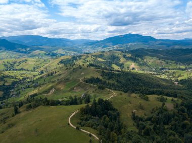 Yazın Ukrayna Karpatları 'nın yeşil dağları. Yamaçlarda kozalaklı ağaçlar. Hava aracı görünümü.
