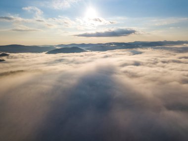 Ukrayna Karpatları 'nda yaz aylarında sislerin üzerinden uçarlar. Ufuktaki dağlar. Yoğun bir sis tabakası daimi bir halıyla dağları kaplar. Hava aracı görünümü.
