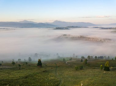 Ukrayna Karpatları 'nda sisin üstünde gün doğumu. Hava aracı görünümü.
