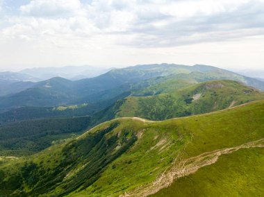 Bulutlu havada Ukrayna Karpatlarının yüksek dağları. Hava aracı görünümü.