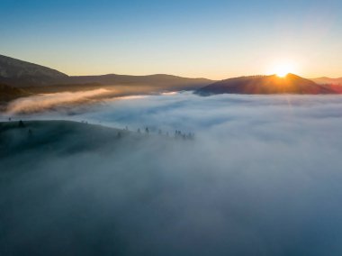 Ukrayna Karpatları 'nda sisin üstünde gün doğumu. Hava aracı görünümü.