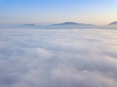 Ukrayna Karpatları 'nda yaz aylarında sislerin üzerinden uçarlar. Ufuktaki dağlar. Hava aracı görünümü.