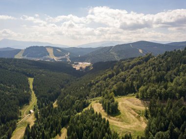 Yazın Ukrayna Karpatları 'nın yeşil dağları. Güneşli bir gün, nadir bulutlar. Hava aracı görünümü.