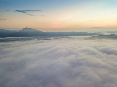 Ukrayna Karpatları 'nda sislerin üzerindeki şafak ışınları. Hava aracı görünümü.