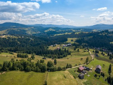 Yazın Ukrayna Karpatları 'nın yeşil dağları. Güneşli bir gün, nadir bulutlar. Hava aracı görünümü.