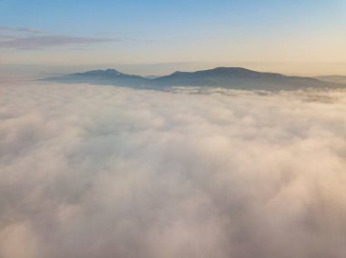 Ukrayna Karpatları 'nda yaz aylarında sislerin üzerinden uçarlar. Ufuktaki dağlar. Hava aracı görünümü.