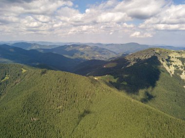 Yazın Ukrayna Karpatları 'nın yeşil dağları. Güneşli bir gün, nadir bulutlar. Hava aracı görünümü.