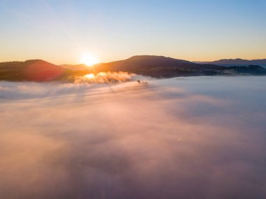 Ukrayna Karpatları 'nda sisin üstünde gün doğumu. Hava aracı görünümü.