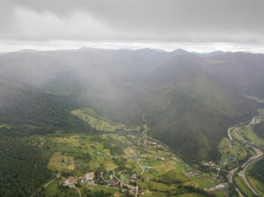 Ukrayna Karpatlarının yeşil dağları bulutların üzerinde dinleniyor. Hava aracı görünümü.