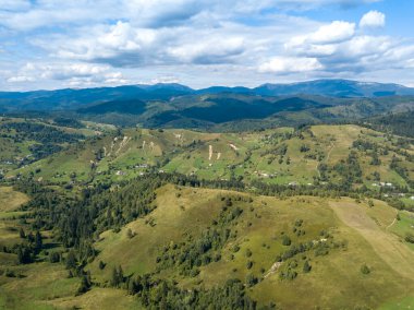 Yazın Ukrayna Karpatları 'nın yeşil dağları. Yamaçlarda kozalaklı ağaçlar. Hava aracı görünümü.