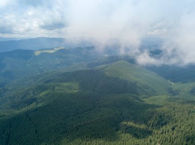 Yazın Ukrayna Karpatları 'nın yeşil dağları. Güneşli bir gün, nadir bulutlar. Hava aracı görünümü.