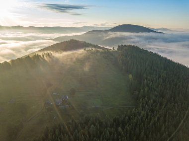 Sisli Karpatlar 'da güneşli bir sabah. Dağları ince bir sis tabakası kaplıyor. Hava aracı görünümü.