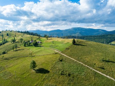 Yazın Ukrayna Karpatları 'nın yeşil dağları. Güneşli bir gün, nadir bulutlar. Hava aracı görünümü.