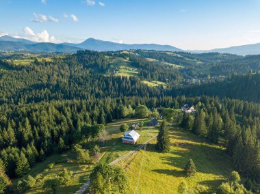Yazın Ukrayna Karpatları 'nın yeşil dağları. Güneşli bir gün, nadir bulutlar. Hava aracı görünümü.