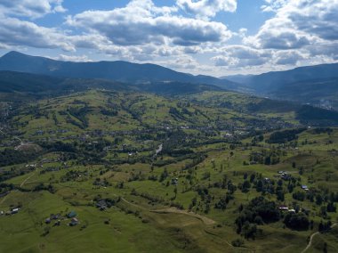 Yazın Ukrayna Karpatları 'nın yeşil dağları. Yamaçlarda kozalaklı ağaçlar. Hava aracı görünümü.