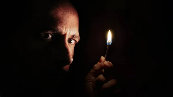 Karanlıkta Elinde Kibritle Kameraya Bakan Endişeli Bir Adam Karartma Konsepti — Stok fotoğraf