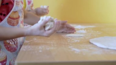 Çocuklar ekmek hamuru yoğurup unla oynuyorlar. Seçici odak