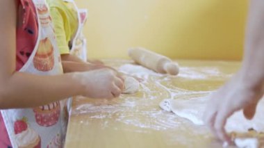 Anne çocuklarıyla pizza hamuru yoğuruyor. Aile yemekleri konsepti. Seçici odak