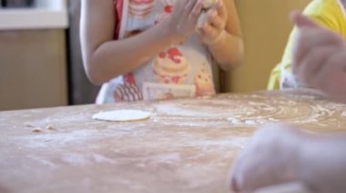 Anne çocuklarıyla pizza hamuru yoğuruyor. Aile yemekleri konsepti. Seçici odak