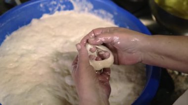 Woman's hands preparing fritters in a frying pan with hot oil.