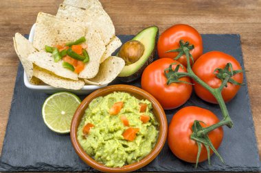 Ev yapımı organik guacamole, domates ve cips. Seçici odak.