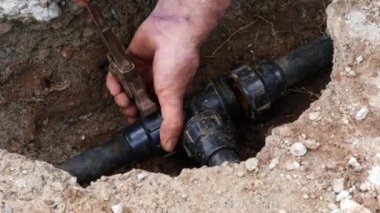 Çiftçi elleri sulama için tarladaki boruları tamir ediyor. Seçici odak.