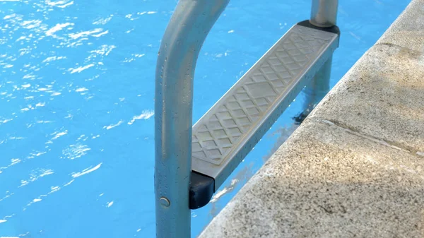 Grab bars ladder in the blue swimming pool. Selective focus. — Foto Stock