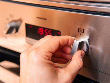 Fırın kontrolü kullanan bir adam.