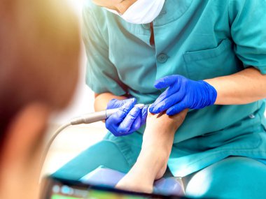 Ayak hastalıkları kliniğinde ayak masajı yapan bir kadın ayak hastalıkları uzmanı. Seçici odak