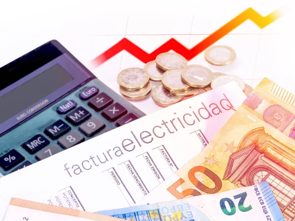 Electricity bill posted in Spanish, next to a graph, a calculator and money. Concept of electricity price increase.