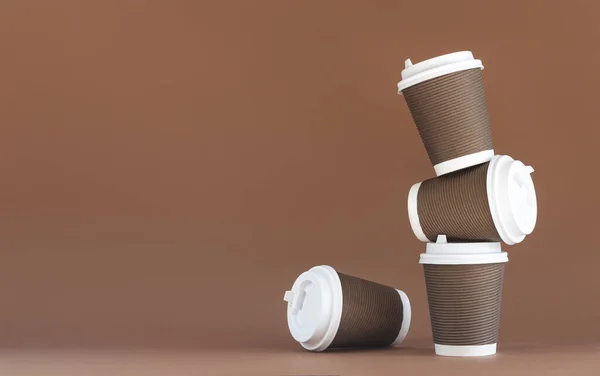 キャップ付き使い捨ての茶色い紙コーヒーカップのスタック — ストック写真