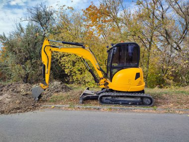 Modern sarı JCB kazıcı veya kazıcı açık havada kazı yapıyor
