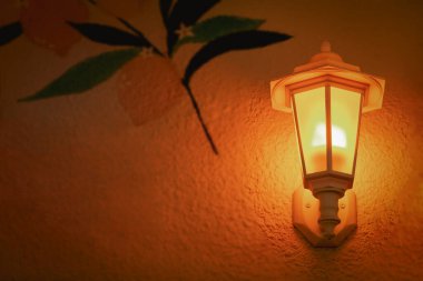 Güzel, eski moda sokak lambası geceleri duvarda.