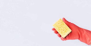 Sarı sünger tutan lastik eldivenli pankart. Temizlik hizmeti konsepti. Metin için boşluk