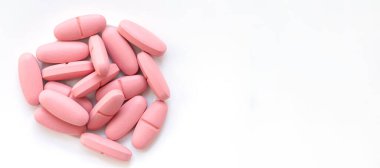 Beyaz arka plana izole edilmiş büyük pembe haplar yığını. Üst görünüm, alanı kopyala