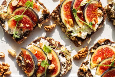 Aperatif crostini ya da incirli bruschetta, krem peynir, mermer tahtada bal. Üst görünüm