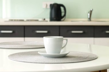 Mutfak masasının üzerinde beyaz kahve fincanı.