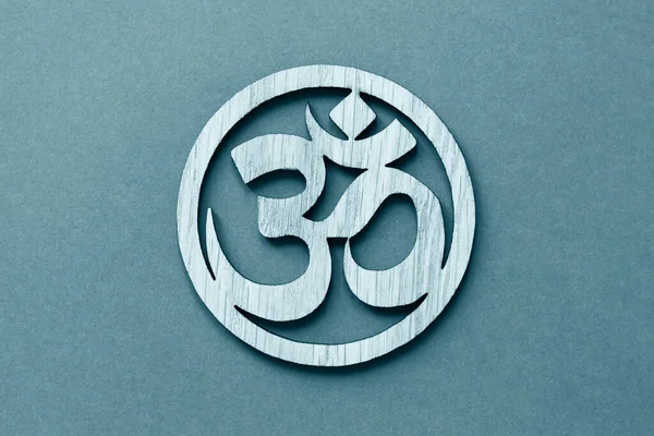 Om or Aum symbol of Hinduism and Buddhism on blue background