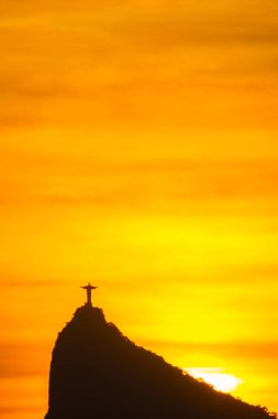 Rio de Janeiro, Brezilya - CIRCA 2021: Cristo Redentor Panoraması (Kurtarıcı İsa) turuncu gökyüzü ile günbatımında