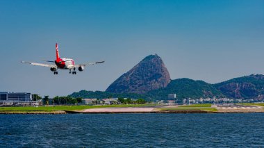 Rio de Janeiro, Brezilya - CIRCA 2020: Santos Dumont ulusal havaalanına ticari uçak iniyor. Rio 'nun turistik merkezi Guanabara Körfezi ve Sugarloaf Dağı' nı görmek mümkün.