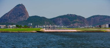 Rio de Janeiro, Brezilya - CIRCA 2020: Santos Dumont ulusal havaalanına ticari uçak iniyor. Rio 'nun turistik merkezi Guanabara Körfezi ve Sugarloaf Dağı' nı görmek mümkün.