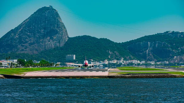 Rio de Janeiro, Brezilya - CIRCA 2020: Santos Dumont ulusal havaalanına ticari uçak iniyor. Rio 'nun turistik merkezi Guanabara Körfezi ve Sugarloaf Dağı' nı görmek mümkün.