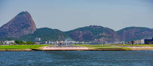 Rio de Janeiro, Brezilya - CIRCA 2020: Santos Dumont ulusal havaalanına ticari uçak iniyor. Rio 'nun turistik merkezi Guanabara Körfezi ve Sugarloaf Dağı' nı görmek mümkün.
