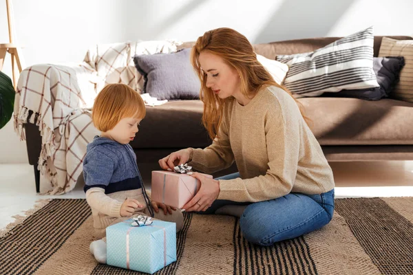 Mamá pelirroja prepara alegremente regalos de Navidad con su hijo —  Fotos de Stock